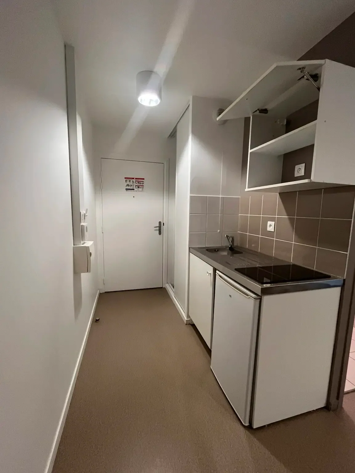 Kitchenette du studio avec évier, plaques, réfrigérateur et placards