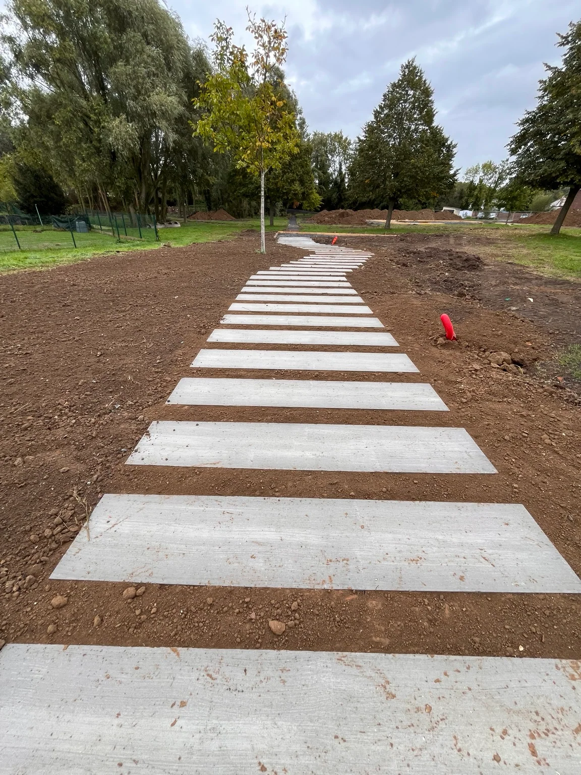 Cheminement en dalles en cours de pose dans le futur jardin public