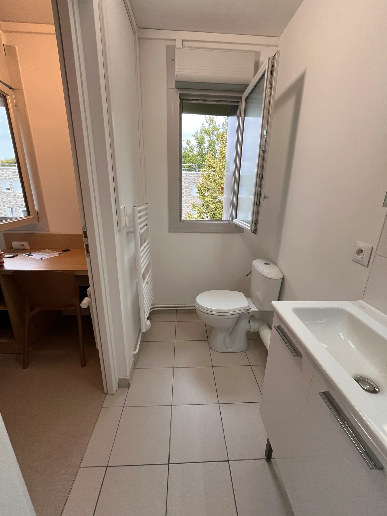 Salle d’eau d’une studette du bâtiment J avec lavabo, toilettes et fenêtre