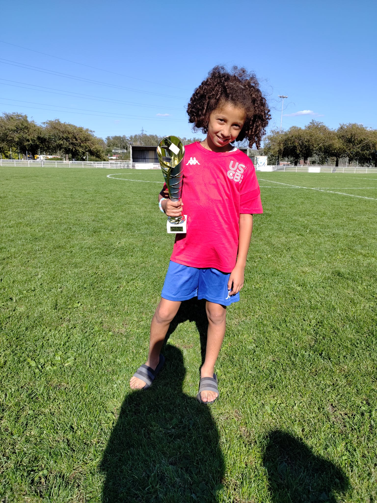 Un jeune joueur du tournoi U11 tenant son trophée